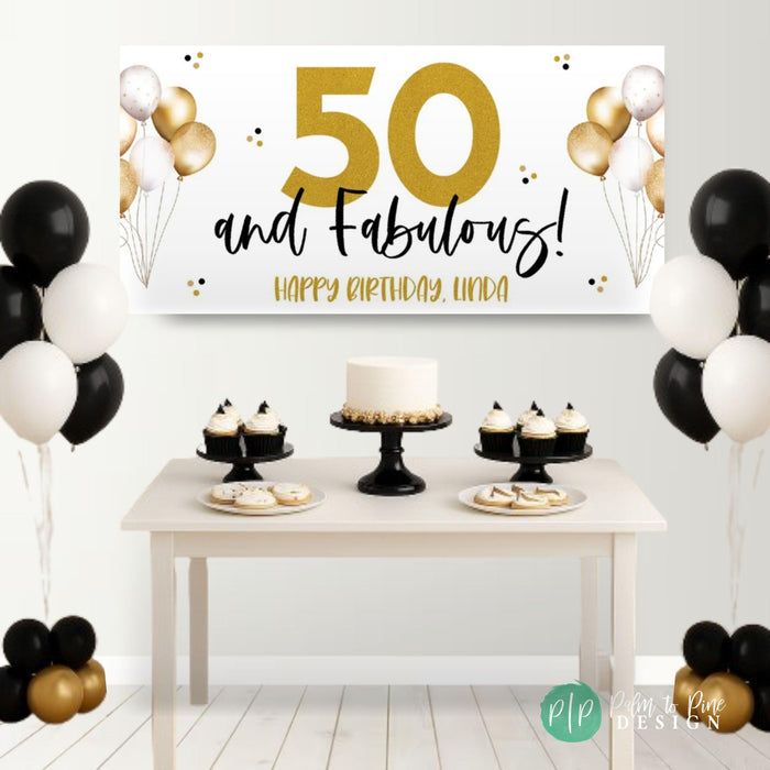 a black and gold 50th birthday party with dessert table, personalized banner that says 50 and fabulous and black and white balloons