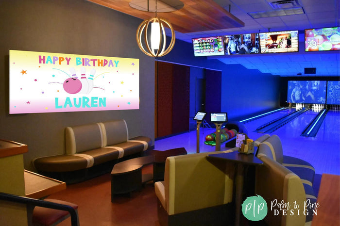 personalized bowling birthday banner hung on the wall at a bowling alley for a party