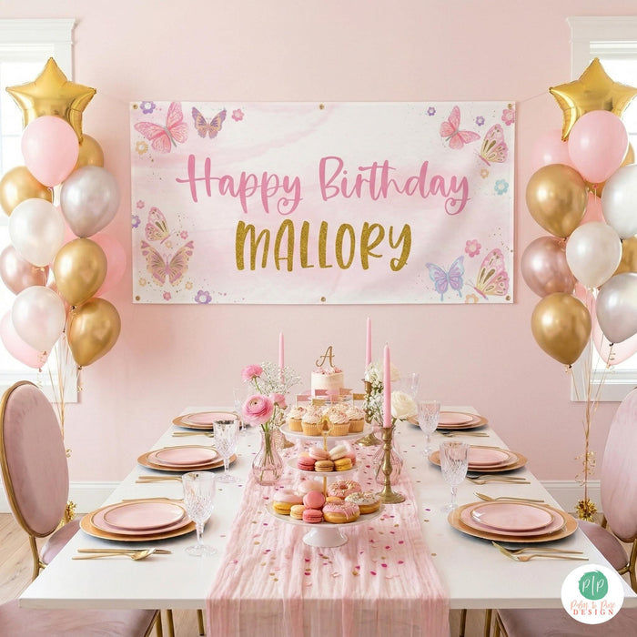 Personalized pink butterfly banner as centerpiece over a girls birthday table setting with elegant party styling