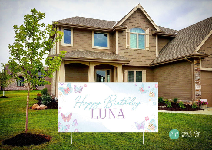 Butterfly-themed birthday party banner with delicate pastel wings and floral accents, personalized with name and age in front yard of house