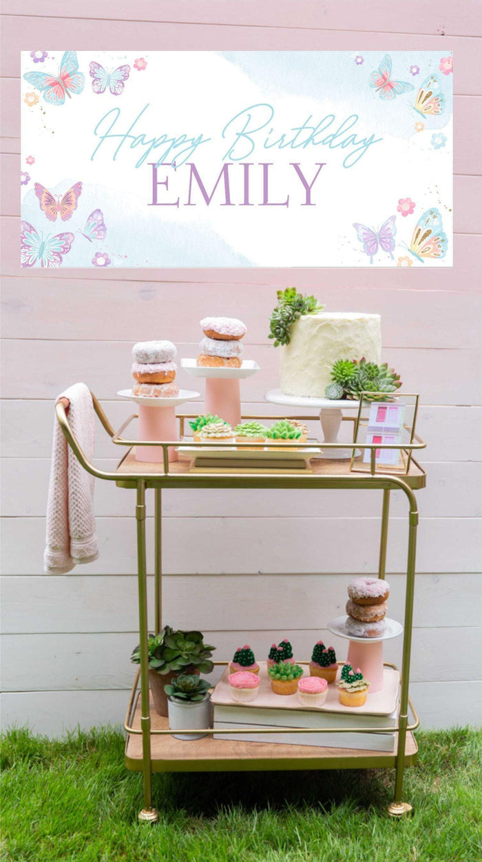 Personalized pastel birthday banner with whimsical butterflies and soft watercolor tones, ideal for girls' parties with pink dessert table