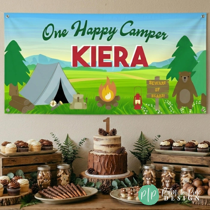 one happy camper birthday banner hanging behind rustic outdoors themed dessert table