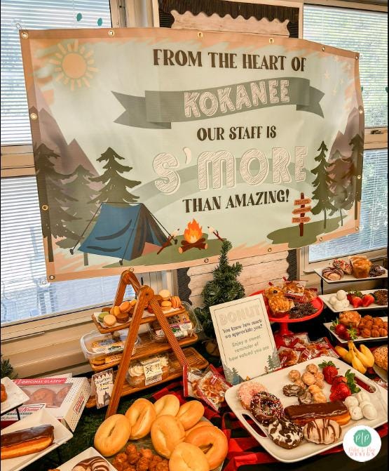 Teacher Appreciation Week display featuring personalized camping themed banner, and breakfast spread