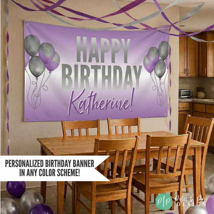 Personalized Happy Birthday Banner in purple and silver hung on wall in kitchen with purple and silver streamers and balloons decorating the space. Message reads "Personalized birthday banner in any color scheme"