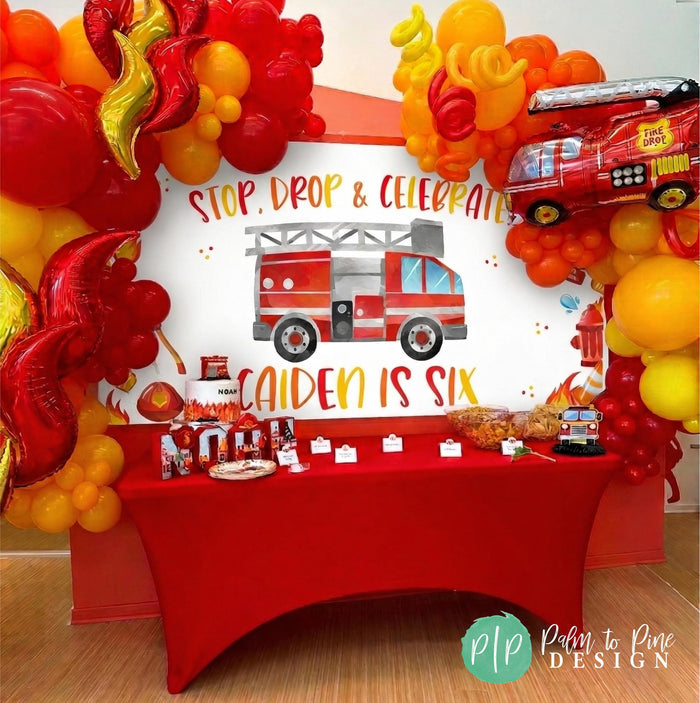 firefighter birthday decorations at kids birthday with personalized banner and fire inspired balloon garland