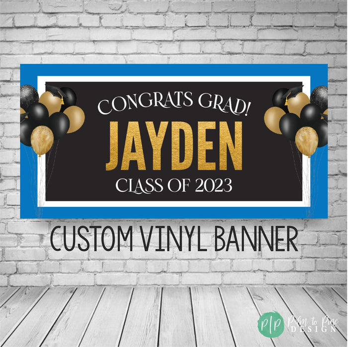 graduation banners in black, blue and gold with balloons with graduation caps on the sides and congrats grad with class of 2025 wording
