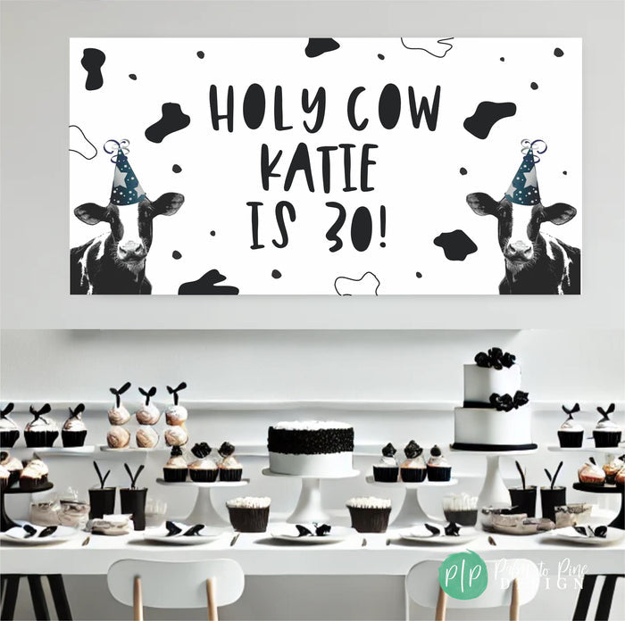 Holy Cow Theme personalized birthday decorations in front of black and white dessert table for Cow birthday party