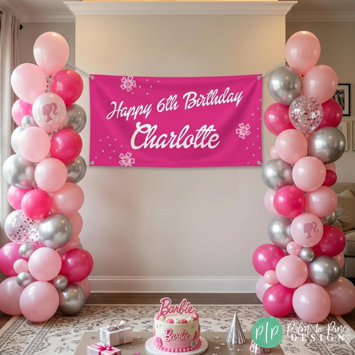 Girls barbie themed birthday party with personalized banner and balloon pedestal. In the forefront is a barbie cake