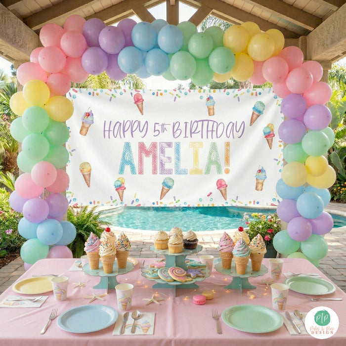 Kids ice cream party decorations with personalized banner and balloon garland in colorful pastels