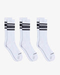 Three pairs of Les Socks in white, laid flat on a white background. The image highlights the mid-calf design with black stripes and the c'est normal logo in contrast stitching.