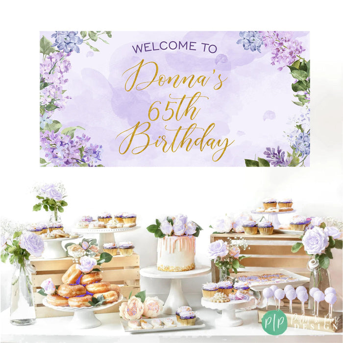 Purple birthday banner with watercolor lilac flowers, perfect for a feminine adult celebration in front of dessert table