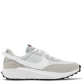 A Nike low-top sneaker in light gray and white, featuring a white Swoosh, white laces, a white heel strap, and a thick white midsole with a black outsole.