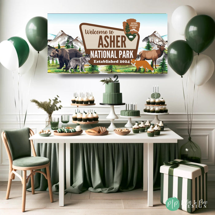Outdoorsy birthday party setup featuring a custom national park banner with forest and mountain theme