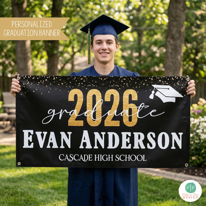 Class of 2026 Black and Gold Graduation banner, held by high school grad wearing a cap and gown in backyard setting