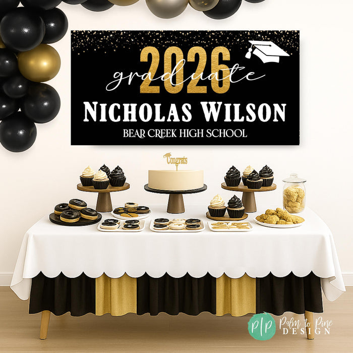 Personalized Class of 2026 graduation banner displayed at a graduation party dessert table in black and gold school colors