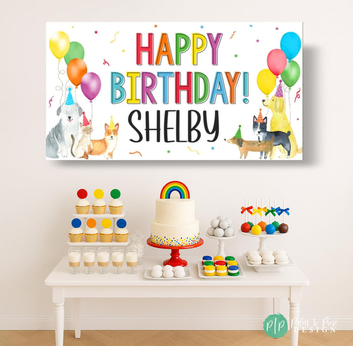 a puppy dog birthday party with a personalized banner behind a dessert table featuring a birthday cake and cupcakes