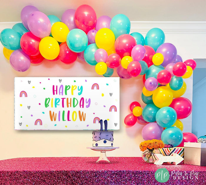 tween girls birthday banner with bright rainbow colors and balloon garland