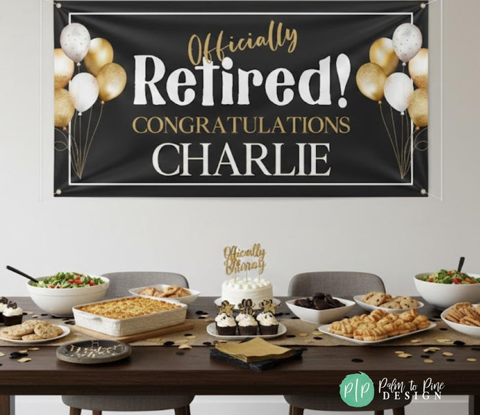 a banner that reads " Officially Retired! CONGRATULATIONS CHARLIE" with gold balloons and confetti surrounding it. The banner is displayed above a table filled with various food items, including a cake, a salad, and other dishes.