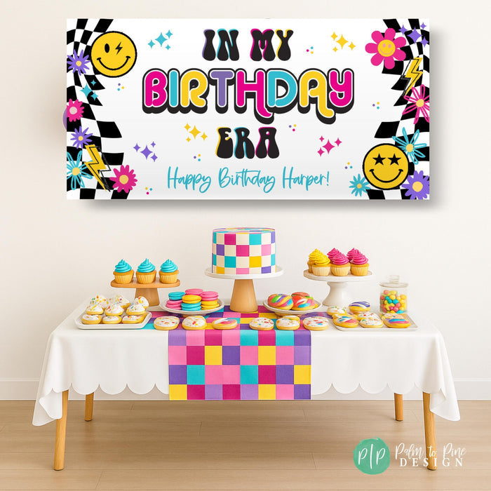 In my Birthday Era Banner with retro checkered pattern, smiley faces and lightening bolts in front of retro dessert table