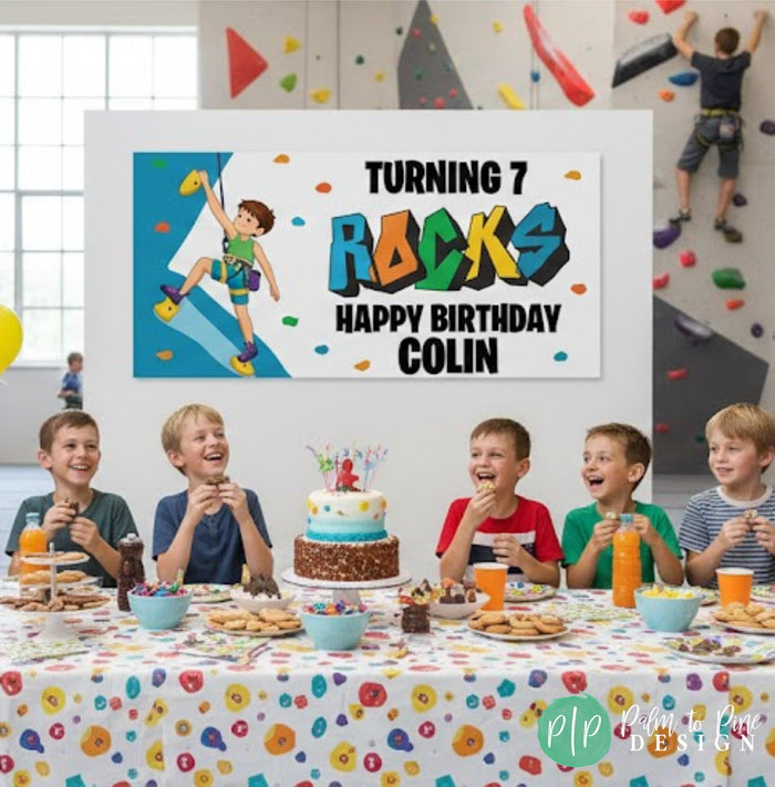 Boys indoor rock climbing birthday party with kids and cake. Background features a personalized birthday banner at a rock climbing gym