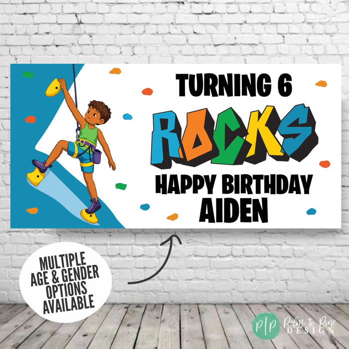 Personalized rock climbing birthday banner for boys displayed on a brick wall backdrop