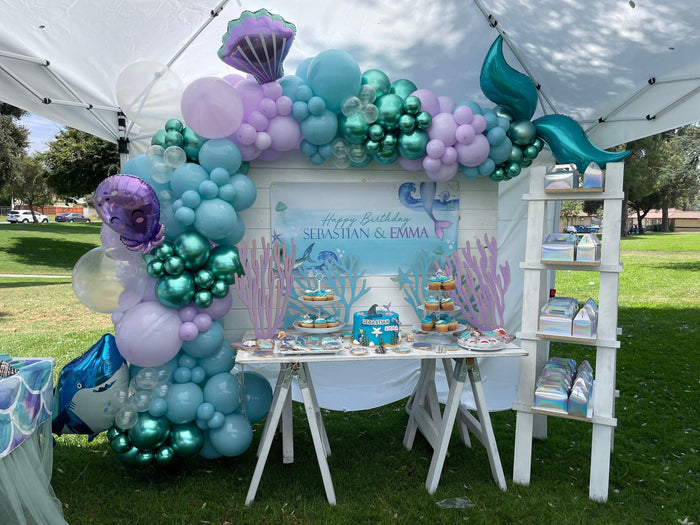 Shark and mermaid themed birthday banner featuring ocean animals like jellyfish and starfish. Blue underwater design for joint boy girl party decor.