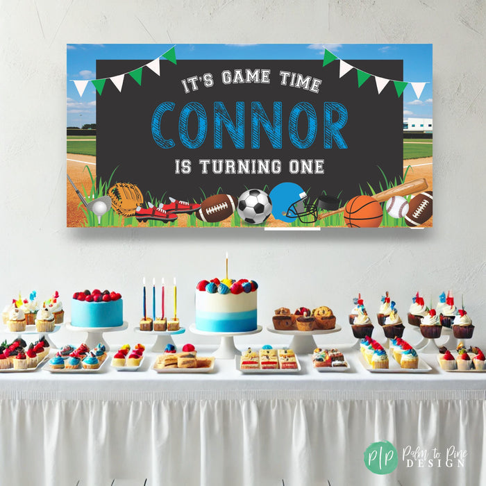 personalized sports birthday banner for kids with a baseball field and chalkboard background. sports balls and equipment sit on the grass on the bottom of the banner
