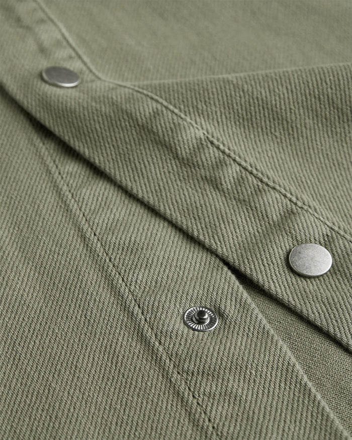 The Bilbao Overshirt in olive — close-up of the textured fabric and snap buttons