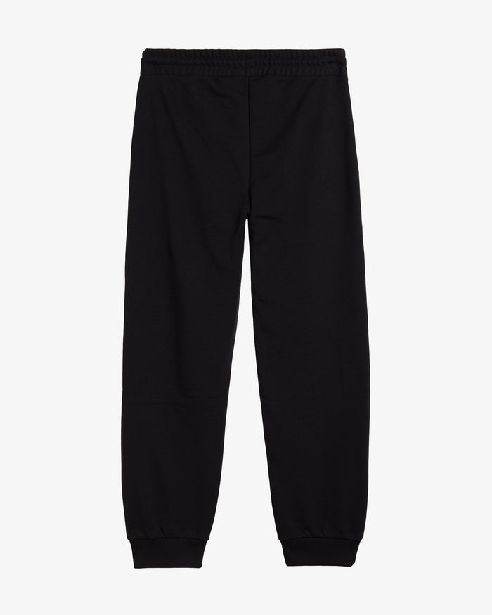 A back view of The Gym Pants in classic black, laid flat on a white background. The image highlights the elastic waist and the wider, longer leg fit.