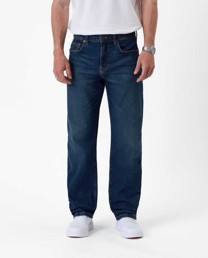 The Jeans Classic Straight Fit in Mid Wash Blue — front view on a model with white sneakers