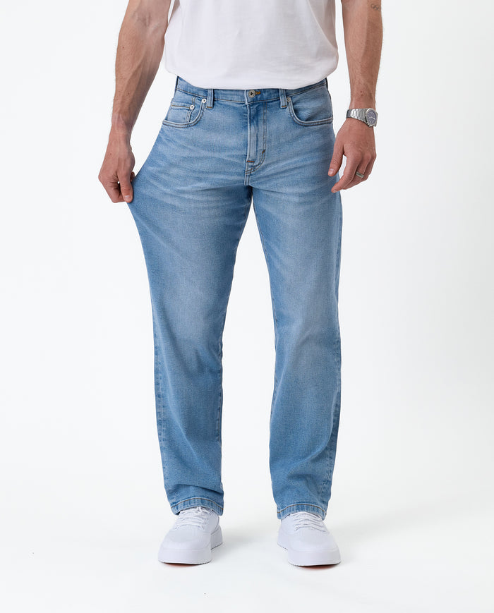 The Jeans Classic Straight Fit in light mid blue — pulling the fabric on the thigh