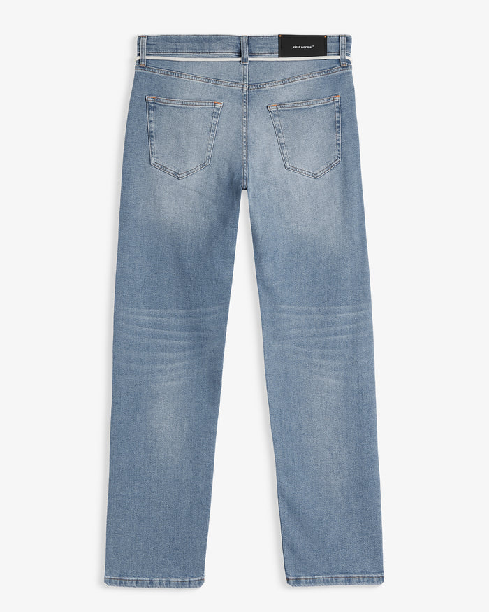 The Jeans Classic Straight Fit in light mid blue — back view with black C'est normal patch