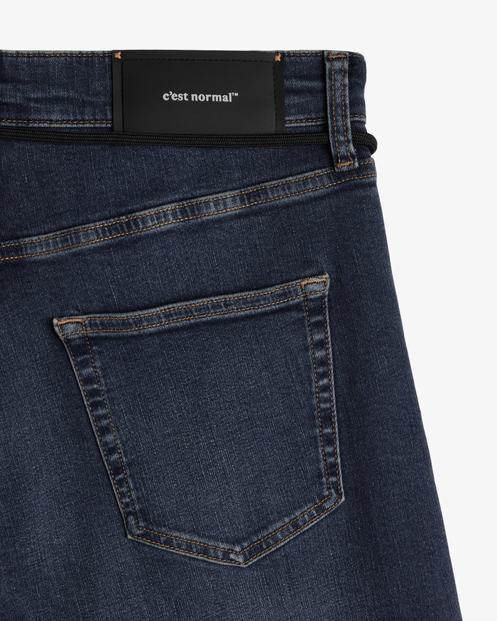 The Jeans Classic Straight Fit in mid wash blue — back view with the black C'est normal patch