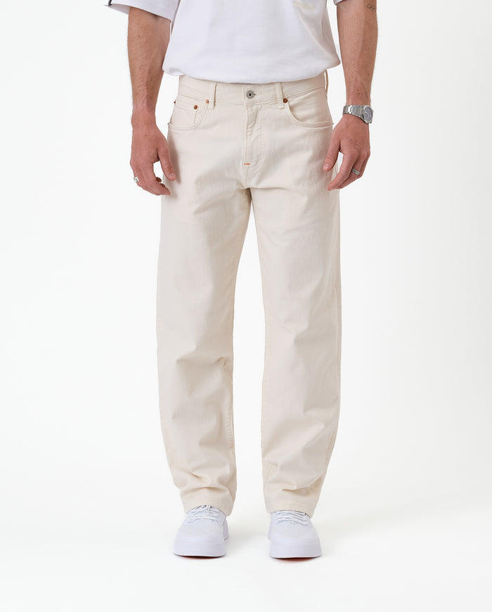 The Jeans Relaxed Straight Fit in ecru — front view worn with white sneakers