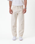 The Jeans Relaxed Straight Fit in ecru — front view worn with white sneakers