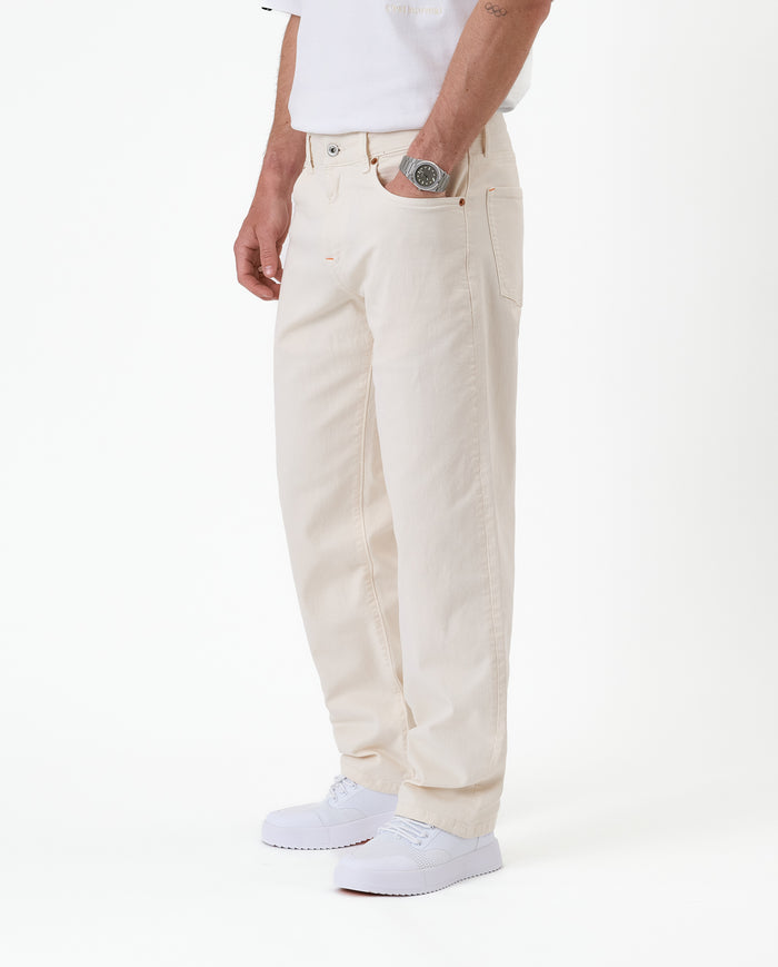 The Jeans Relaxed Straight Fit in ecru — side view worn with white sneakers