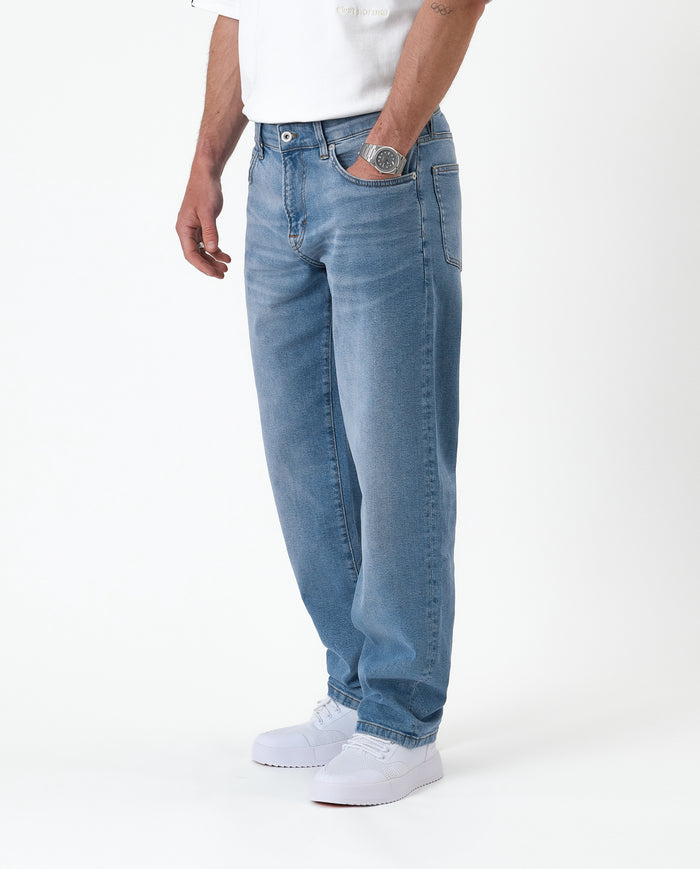 The Jeans Relaxed Straight Fit in light midwash — worn with white sneakers