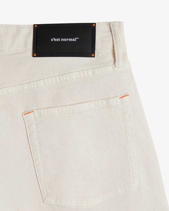 The Jeans Relaxed Straight Fit in ecru — back view with a black C'est normal rubber patch