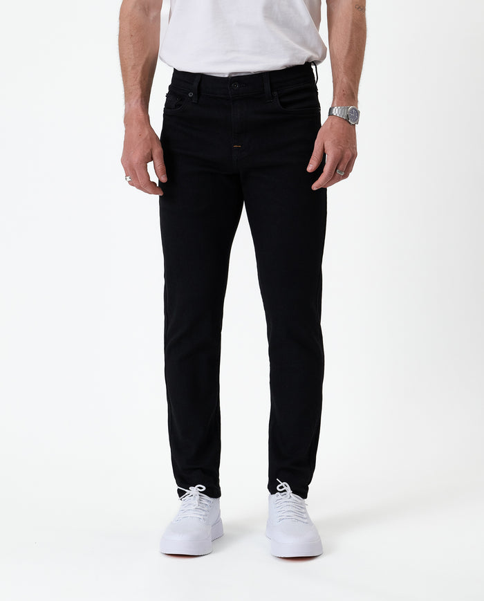 The Jeans Skinny Fit in jet black — front view worn with white sneakers