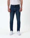 The Jeans Skinny Fit in Midwash — front view worn with white sneakers