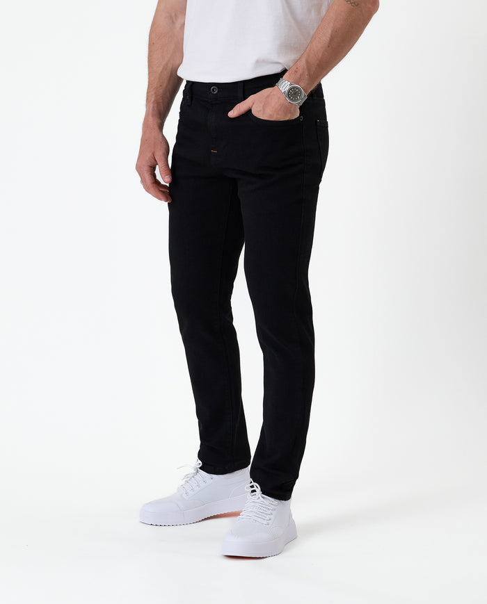 The Jeans Skinny Fit in Jet Black — worn with white sneakers