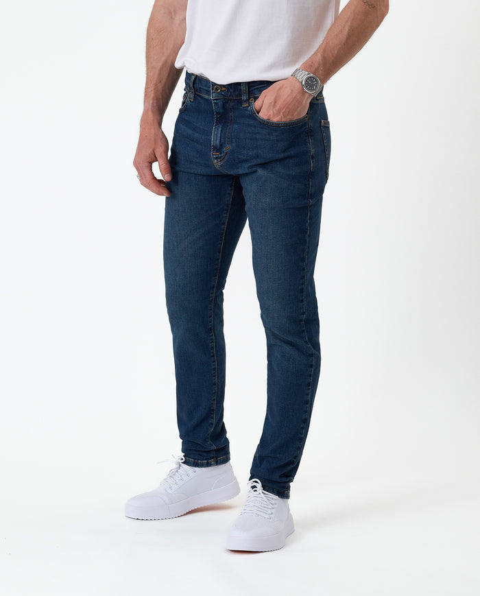The Jeans Skinny Fit in midwash — worn with white sneakers