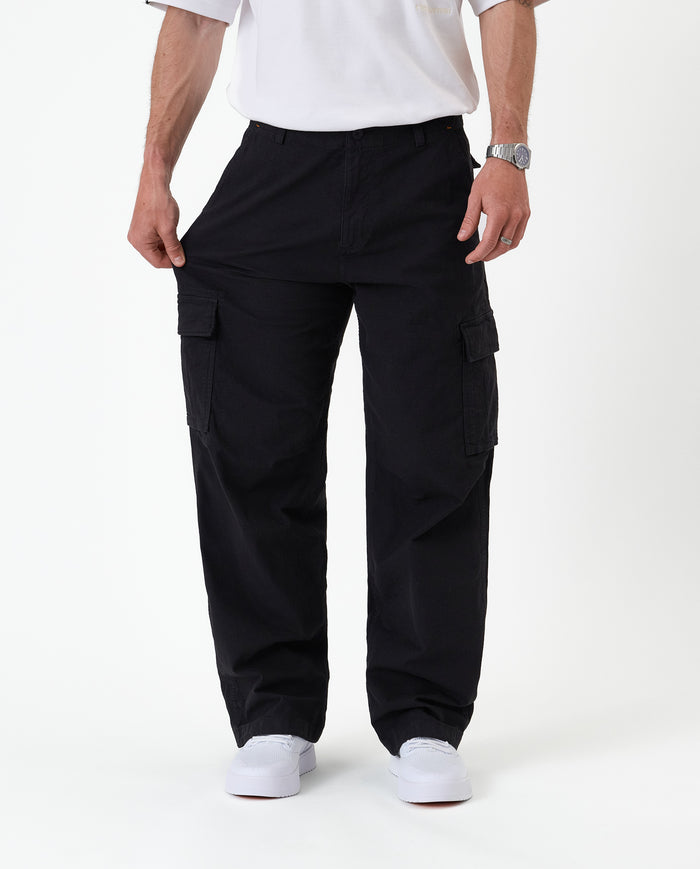The Monterey Cargo Pant in black — stretching the fabric to show the flexible comfort stretch