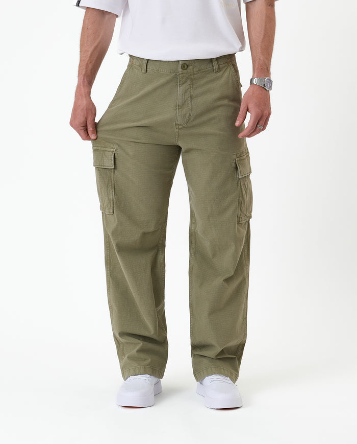 The Monterey Cargo Pant in Light Khaki — model pulling the fabric to show the comfort stretch