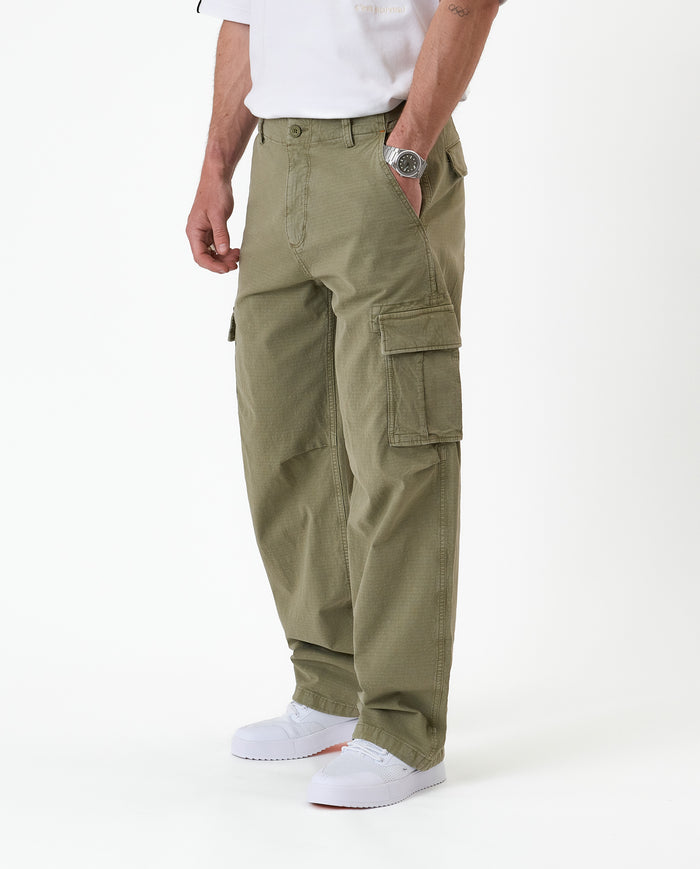The Monterey Cargo Pant in Light Khaki — side view showing the cargo pocket and white sneakers
