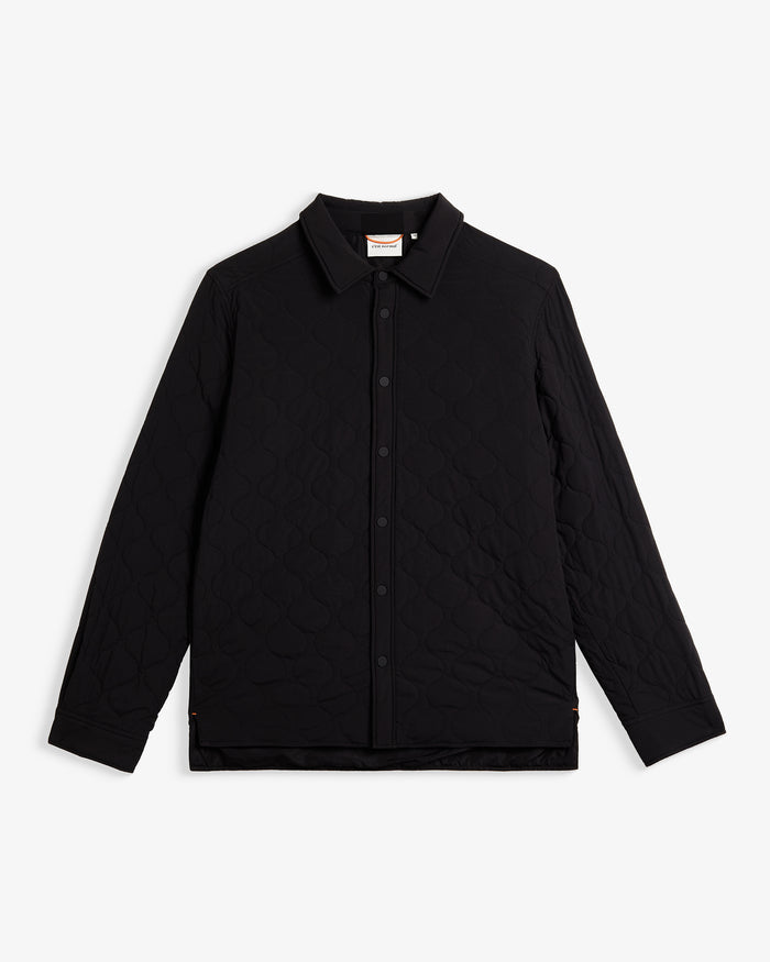 A front view of The Quilted Overshirt in black, laid flat on a white background. The image highlights the clean lines, signature wave quilting, and the c'est normal logo on the inner collar label.