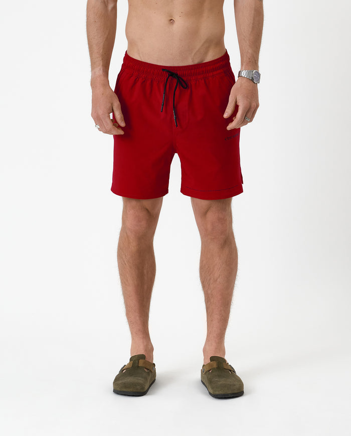 The Shorts in red — front view worn with olive green suede clogs