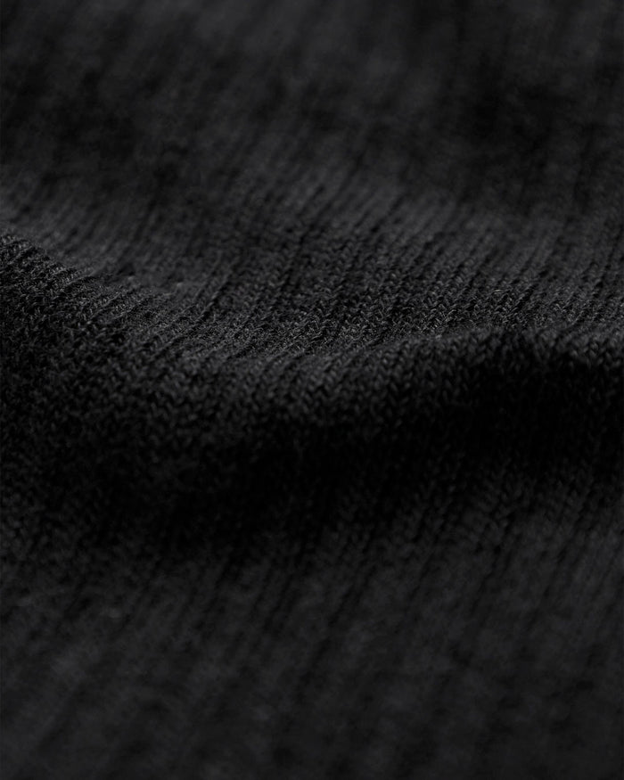 A close-up shot of the black knitted fabric of The Sock, highlighting its soft texture.