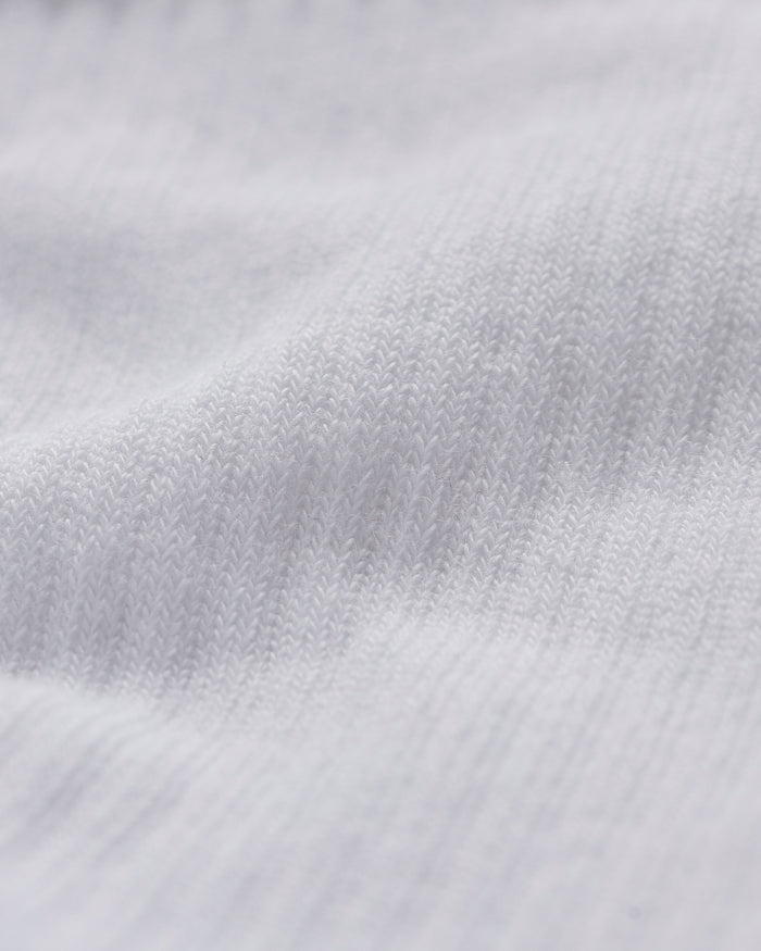 A close-up shot of the soft, white knitted fabric of The Sock White, highlighting its fine texture.