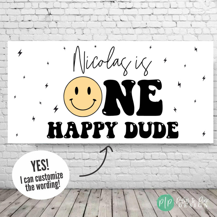 A modern 'One Happy Dude' birthday banner featuring a bold design with a yellow smiley face and lightning bolts for a fun and trendy first birthday celebration.